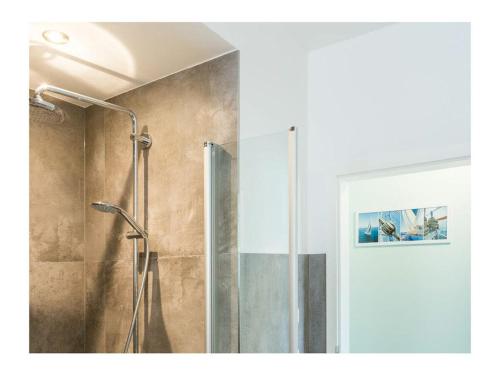 a shower with a glass door in a bathroom at Three-master house no 3 in Breege