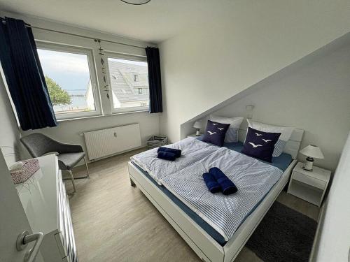 a bedroom with a bed with blue pillows on it at Lütt Matten Comfortable holiday residence in Dranske