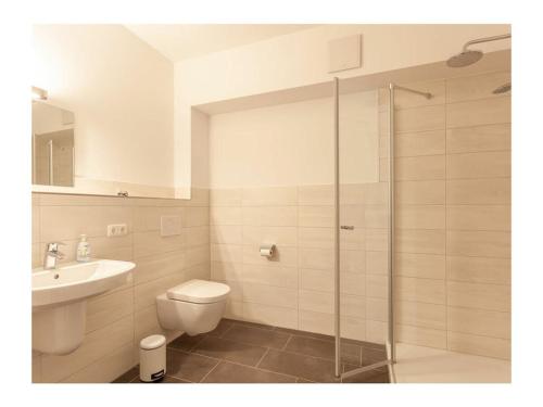 a bathroom with a shower and a toilet and a sink at Three-master house no 2 in Breege