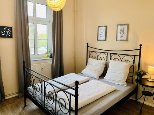a bedroom with a black bed with white pillows and a window at Roßplatz in the center in Leipzig