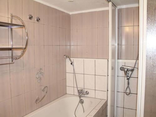 a bathroom with a shower and a bath tub at Vulkaneifel Comfortable holiday residence in Daun