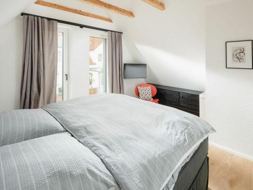 ein weißes Schlafzimmer mit einem Bett und einem Fenster in der Unterkunft Mooi 2 Comfortable holiday residence in Norderney