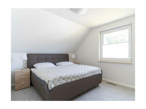a bedroom with a large bed and a window at Meerzeit Comfortable holiday residence in Juliusruh