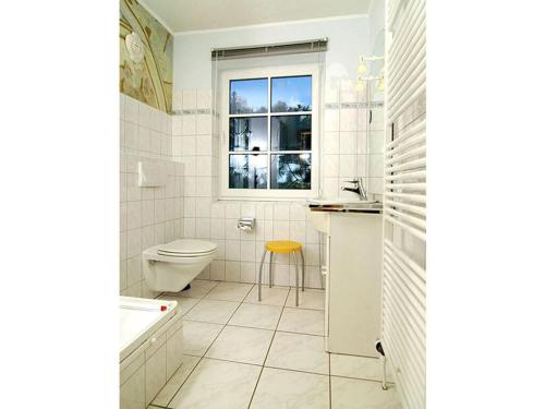 a white bathroom with a toilet and a window at Luxury house R1 Comfortable holiday residence in Sankt Peter-Ording