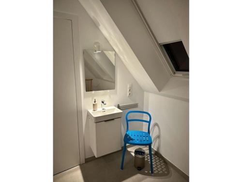 a blue chair in a bathroom with a sink at Jordans Kate Comfortable holiday residence in Xanten