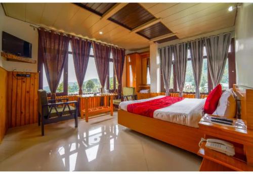 een slaapkamer met een bed en een aantal ramen bij Goroomgo Bala Paradise Munsyari - Himalayan View Room in Munsyari