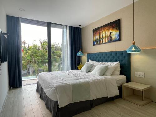 a bedroom with a large bed and a large window at Villa Oceanami - phước hải - bà rịa - vũng tàu in Long Hai