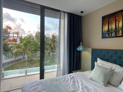 um quarto com uma cama e uma grande janela em Villa Oceanami - phước hải - bà rịa - vũng tàu em Long Hai