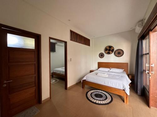 ein Schlafzimmer mit einem Bett und eine Tür mit einem Spiegel in der Unterkunft Villa Son Sun in Uluwatu
