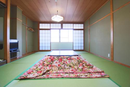 Cette chambre dispose d'un grand lit de fleurs au sol. dans l'établissement Ryokan Nakaya, à Muraoka