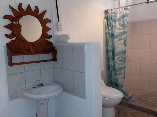 a bathroom with a sink and a toilet and a mirror at B&B Il Padrino in Puerto Jiménez