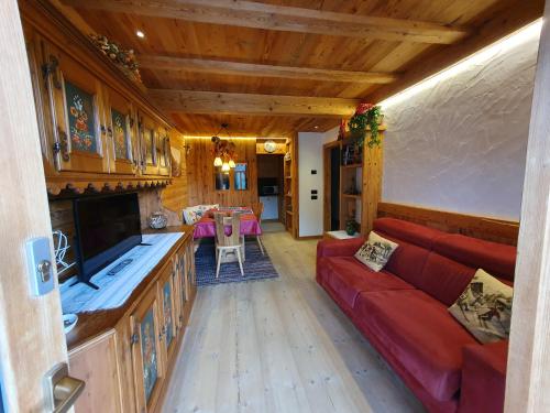 a living room with a red couch in a house at Daniela Apartment in Cortina dʼAmpezzo