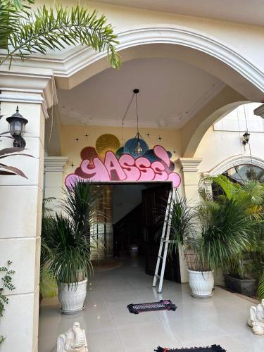 YASSS LGBTQ Guesthouse Siem Reap في سيام ريب: مدخل لمبنى عليه لوحه ورديه