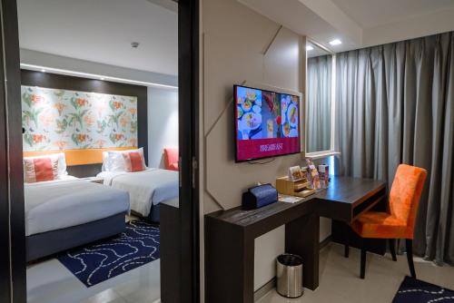 a hotel room with two beds and a desk at Hotel Clover Asoke - SHA Extra Plus in Bangkok
