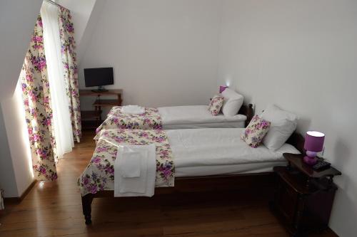 a bedroom with a bed with a table and flowers at Guest House Nocturno in Berkovitsa
