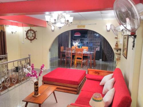 a living room with a red couch and a table at Imperial Heritage Home in Port Blair