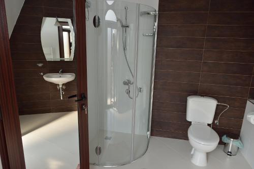 a bathroom with a shower and a toilet and a sink at Guest House Nocturno in Berkovitsa