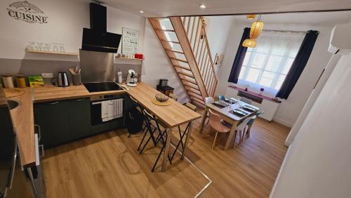- une cuisine avec une table en bois et un comptoir dans l'établissement Maison rénovée, Agen centre, à Agen