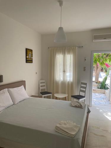 a bedroom with a bed and two chairs and a patio at Villa Sylvia 1 Matala in Matala