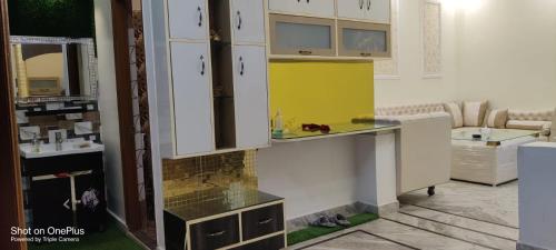 a kitchen with white cabinets and a yellow counter at Indipendent Home Stay at Jankupuram Lucknow in Lucknow