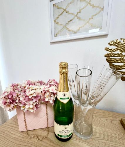 a bottle of champagne and a vase and flowers at BeoCity 011 in Novi Beograd