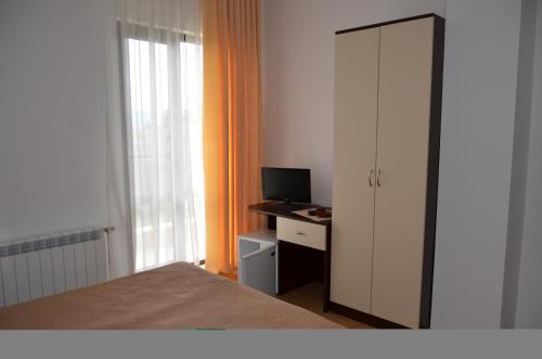 a bedroom with a bed and a desk with a computer at Guest House Nocturno in Berkovitsa