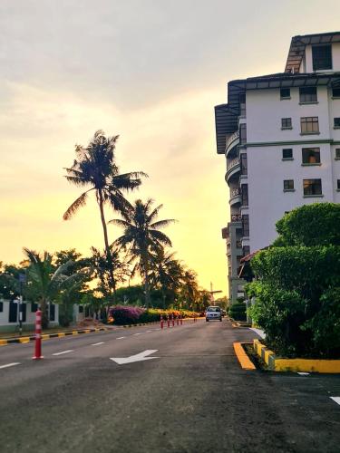 an empty street with palm trees and a building at Mahkota Seaview Condo Homestay Near A'Famosa jonker Melaka in Melaka