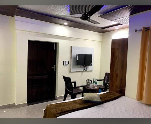 Schlafzimmer mit einem Bett, einem Tisch und einem TV in der Unterkunft Goroomgo Tapovan Residency Haridwar - Excellent Service Recommended in Haridwar