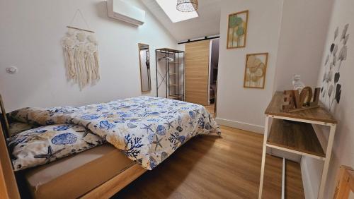 a bedroom with a bed with blue and white sheets at Maison rénovée, Agen centre in Agen