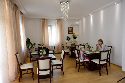 two girls sitting at a table in a dining room at Guest House Nocturno in Berkovitsa