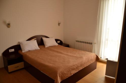 a bedroom with a bed with two pillows on it at Guest House Nocturno in Berkovitsa