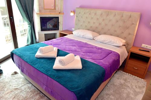 ein Schlafzimmer mit einem Bett mit zwei Handtüchern darauf in der Unterkunft tokastro in Arachova