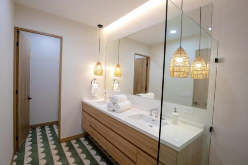 a bathroom with a sink and a mirror at Brand New 2024 Two Bedroom Jungle View Condo with Pool in Nosara