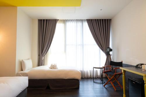 pokój hotelowy z 2 łóżkami i oknem w obiekcie 凝萃文旅台中車站店 NCH - NingCui Business Hotel w mieście Taizhong