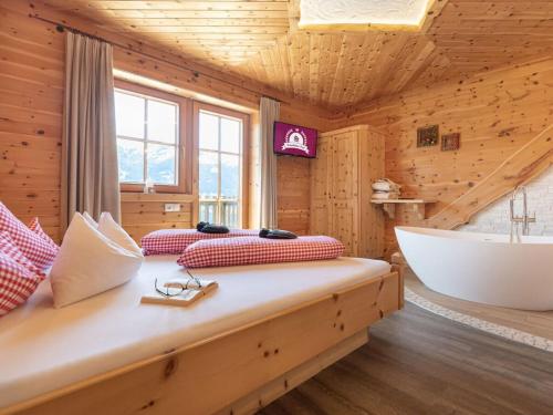 a bedroom with a large bed and a bath tub at Wellness Chalet Bergschlössl in Hippach