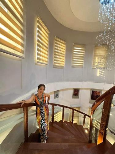 una mujer está de pie en una escalera en un edificio en RosePlace Guesthouse en Tangub