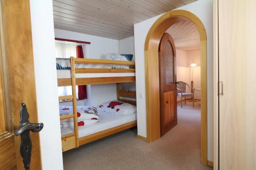 einen Flur mit 2 Etagenbetten in einem Zimmer in der Unterkunft Hotel Alpina Dependance vom Hotel Desiree in Grächen