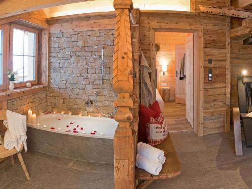 a bath tub in a room with a brick wall at Romantic Chalet Waldschlössl in Hippach