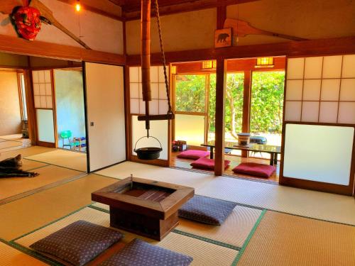 een woonkamer met een tafel en een aantal ramen bij いろり庵 in Tateyama