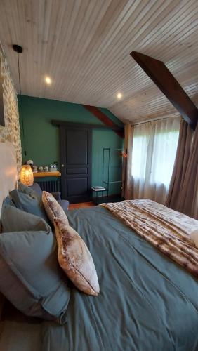 ein Schlafzimmer mit einem großen Bett mit einem großen Stein darauf in der Unterkunft Les 3 Roses in Anjouin