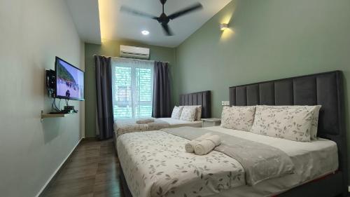 een slaapkamer met een groot bed en een televisie bij Pulau Ketam D'island beds&cafe in Bagan Pulau Ketam