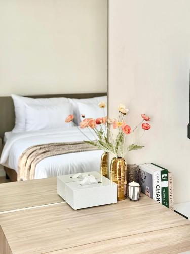 een slaapkamer met een bed en een tafel met bloemen bij สุขใจแกรนด์ in Loei