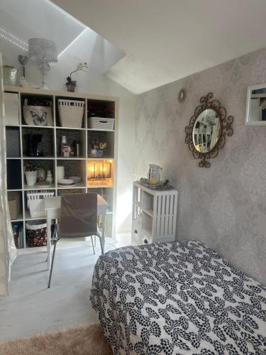 1 dormitorio con cama, mesa y espejo en Small guest room en Turku