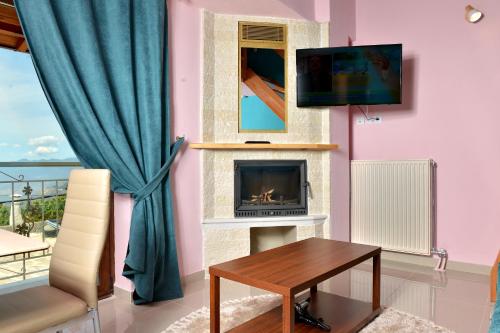 a living room with a fireplace and a tv at tokastro in Arachova