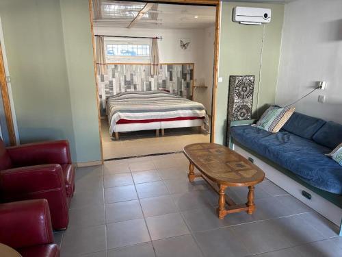 uma sala de estar com um sofá e uma cama em B & B Florence et Francis em Cuxac-dʼAude
