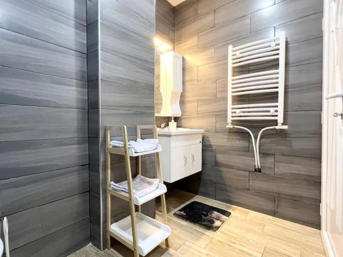 a bathroom with a sink and a mirror and a shelf at Superbe appartement au cœur de Jijel in Jijel