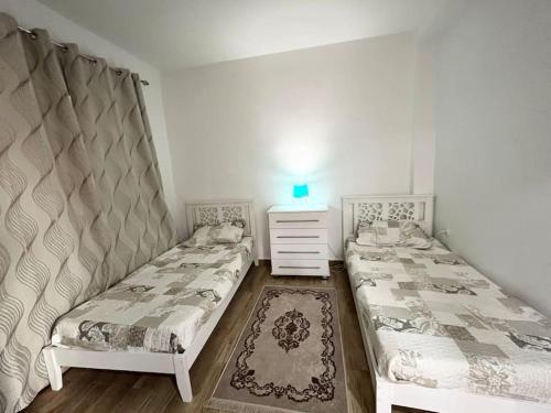 a bedroom with two beds and a dresser at Superbe appartement au cœur de Jijel in Jijel