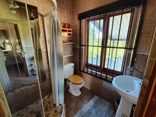 een badkamer met een toilet, een douche en een wastafel bij Die Oog in Richards Bay