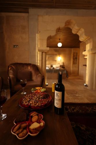 a bottle of wine and two plates of food on a table at Cappadocia View Suit in Goreme