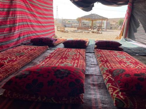 a group of three beds in a tent at חאן נחל חווה Han Nahal Hava in Mitzpe Ramon